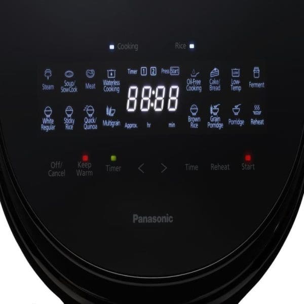 Panasonic rice cooker digital display panel showing cooking modes, timer settings, and control buttons for multifunctional meal preparation on black appliance surface.