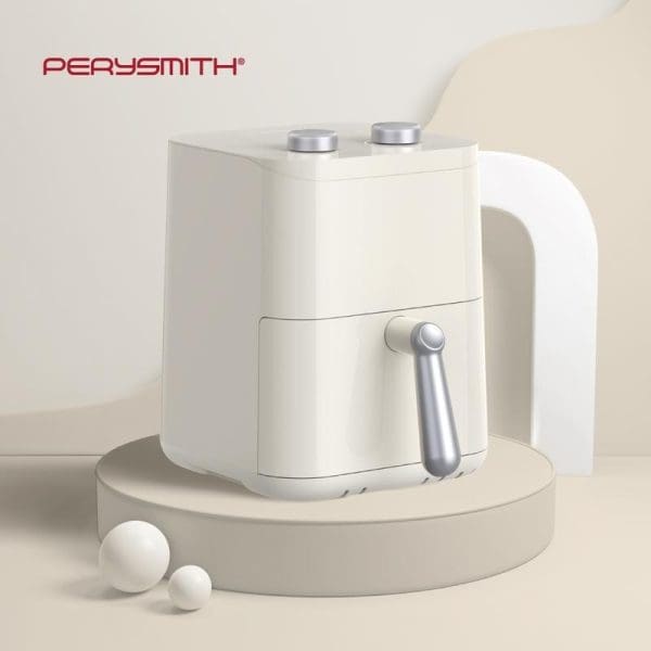 PerySmith PS1530 EcoHealth Series white compact air fryer with silver control knobs and handle, displayed on beige circular platform with decorative white spheres.