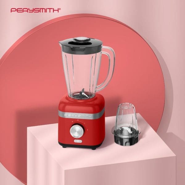 Red PerySmith PS3250 High Speed Blender with clear glass pitcher, black lid, and additional grinding cup accessory displayed on white platform with pink backdrop.