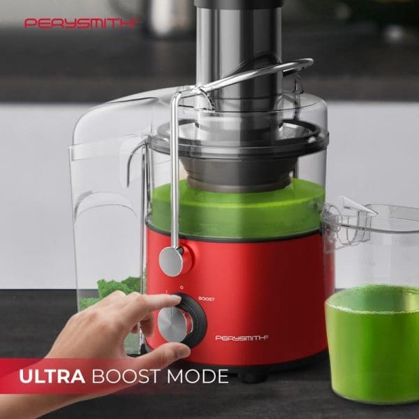 PerySmith J2000 red juice extractor with Ultra Boost Mode, hand adjusting control dial, green juice being extracted into clear container on kitchen counter.