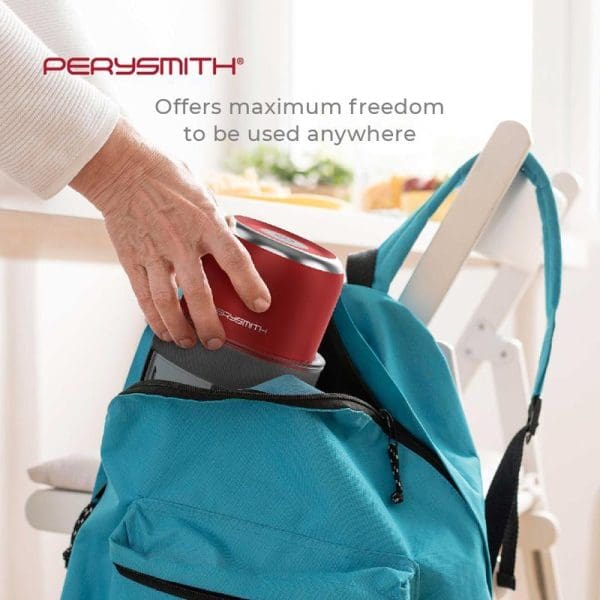 Hand placing red PerySmith PS250 cordless mini food chopper into blue backpack, demonstrating portable convenience for travel and outdoor cooking needs.