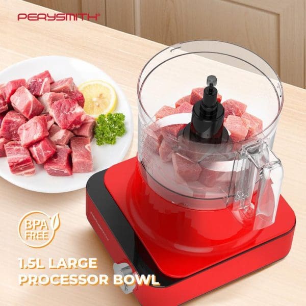 PerySmith PS6500 red food processor with 1.5L clear bowl containing raw meat cubes, white plate with diced beef beside it, BPA-free label visible.