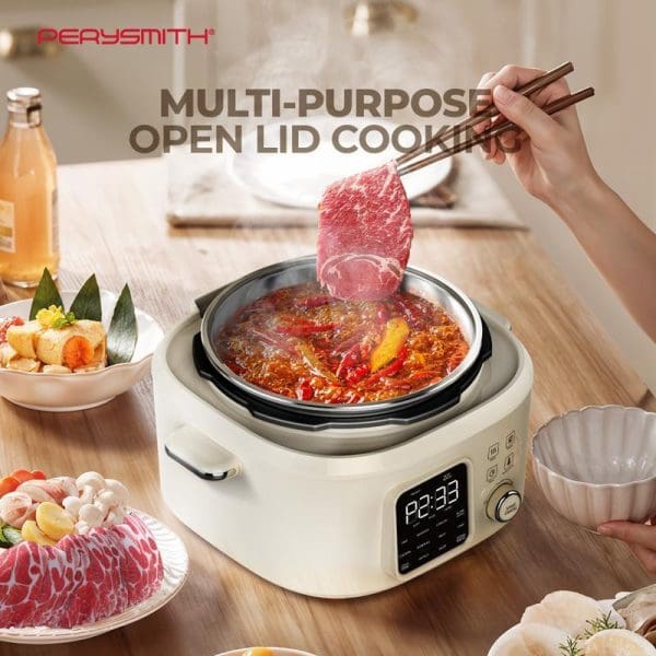 PerySmith PC1000 multi-purpose open lid pressure cooker with digital display cooking red meat in spicy broth, surrounded by raw ingredients and chopsticks.