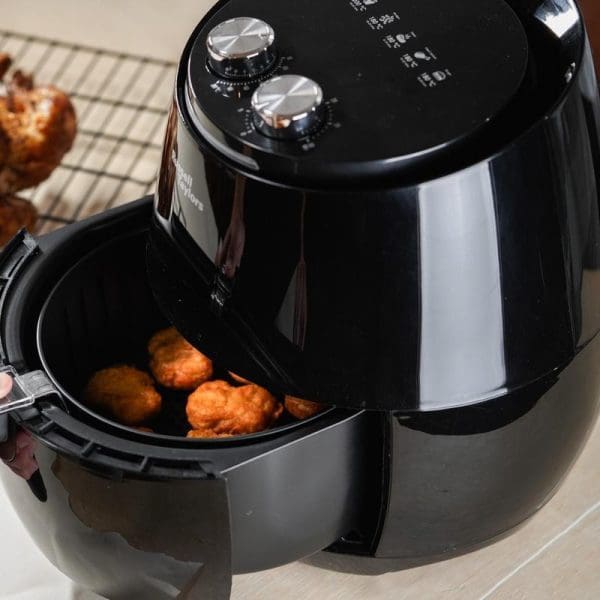 Russell Taylors Air Fryer XL 4.8L AF-34 in black with open basket containing golden fried food, digital control panel with two dials visible on top.