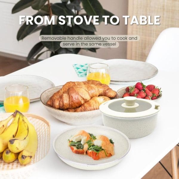 Russell Taylors detachable handle non-stick cookware set with fry pan and sauce pan displaying breakfast spread including croissants, strawberries, and orange juice on white table.