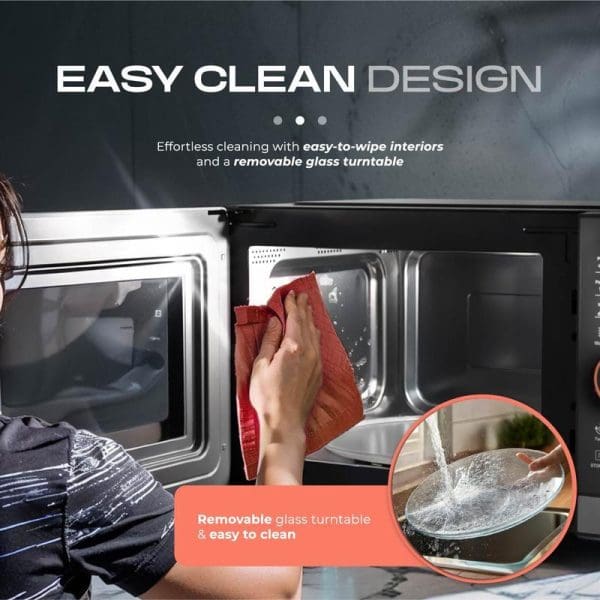 Russell Taylors Digital Microwave Oven 23L M8 featuring easy clean design with removable glass turntable being wiped with red cloth by hand.