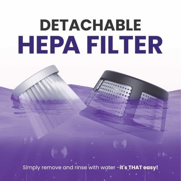 Russell Taylors VM-10 Dust Mite Vacuum Cleaner with detachable HEPA filter shown submerged in purple water, demonstrating easy removal and rinsing capability for maintenance.
