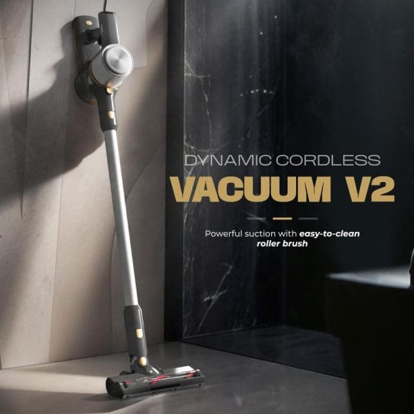 Russell Taylors Dynamic Cordless Vacuum V2 with powerful suction and easy-to-clean roller brush, displayed against marble surface next to product packaging box.
