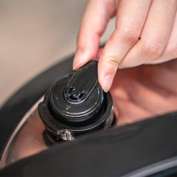 Hand opening black pressure release valve on Russell Taylors Electric Pressure Cooker PC-80 8L stainless steel rice cooker lid.