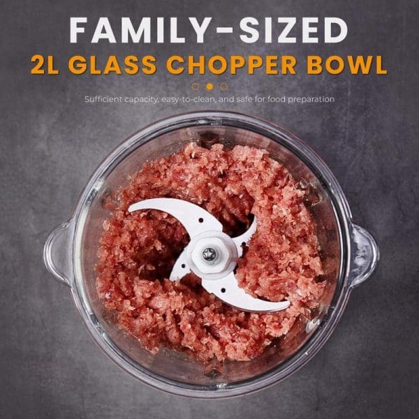 Russell Taylors FC1 Food Chopper with 2L glass bowl containing chopped red meat, featuring white S-blade and handles, marketed as family-sized food processor.