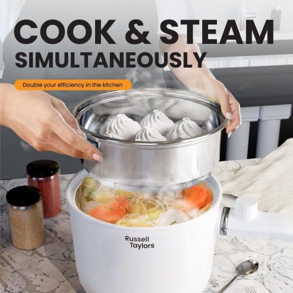 Russell Taylors MC15 1.5L electric multi cooker with steaming basket, showing dumplings being steamed above vegetables cooking below simultaneously in white non-stick pot.