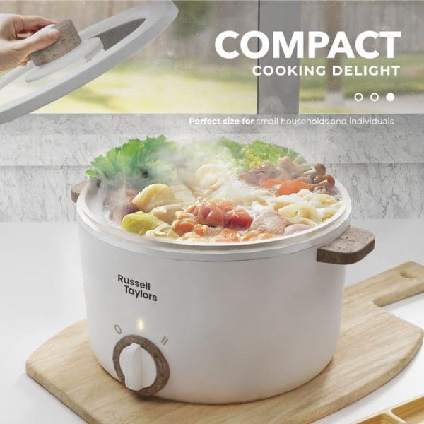 Russell Taylors 2.5L white compact electric multi cooker with steaming vegetables and noodles, featuring non-stick interior and control dial, perfect for small households.