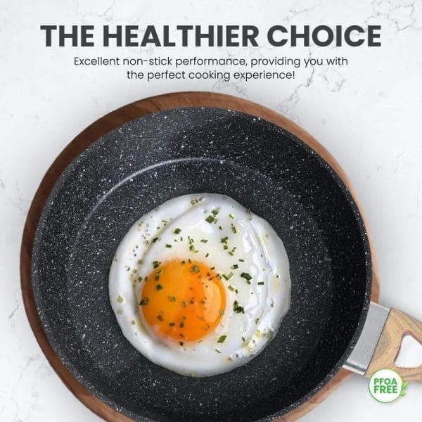 Russell Taylors Romano non-stick frying pan with cooked sunny-side up egg garnished with herbs, showcasing PFOA-free healthy cooking performance on marble surface.