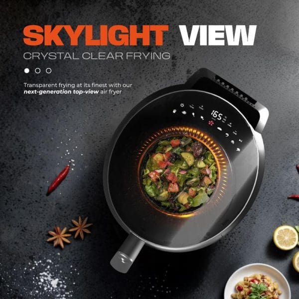 Russell Taylors Skylight View Bladeless Air Fryer 5.5L with transparent top-view design, digital display, cooking vegetables inside, surrounded by spices and ingredients on dark surface.
