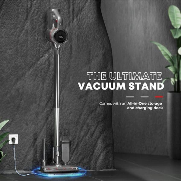 Russell Taylors Swift+ Cordless Vacuum Cleaner with illuminated charging stand and storage dock against dark textured wall with green plant.