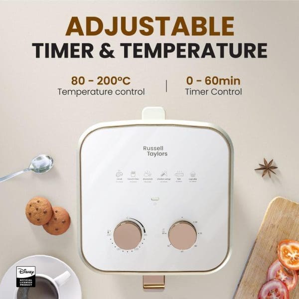 Russell Taylors Disney Mickey retro air fryer with adjustable timer and temperature controls, featuring white design with gold accents and cooking accessories around it.