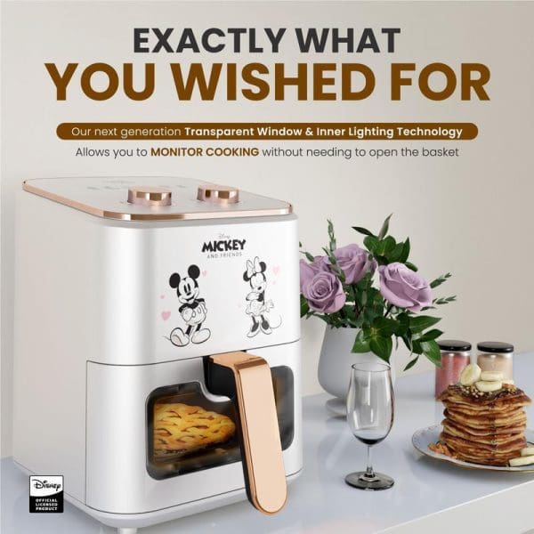 Russell Taylors Disney Mickey Mouse air fryer with transparent window, rose gold accents, 4.5L capacity, shown with cooked food and kitchen styling on counter.