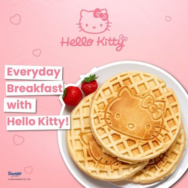 Russell Taylors x Sanrio Hello Kitty Waffle Maker MW-25 with golden Hello Kitty-shaped waffles on white plate, strawberries, pink background with Hello Kitty branding.