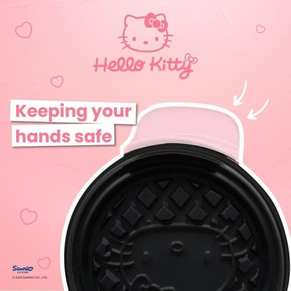 Hello Kitty waffle maker with pink branding, showing black non-stick cooking plates with Hello Kitty face pattern, emphasizing hand safety features on pink background.