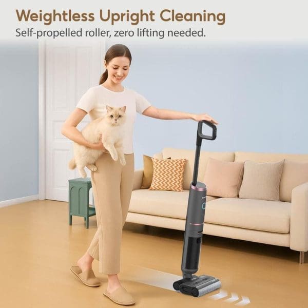 Wanita memegang kucing sambil menggunakan Corvan W6 Pro Cordless Wet & Dry Vacuum untuk membersih lantai kayu di ruang tamu yang selesa.
